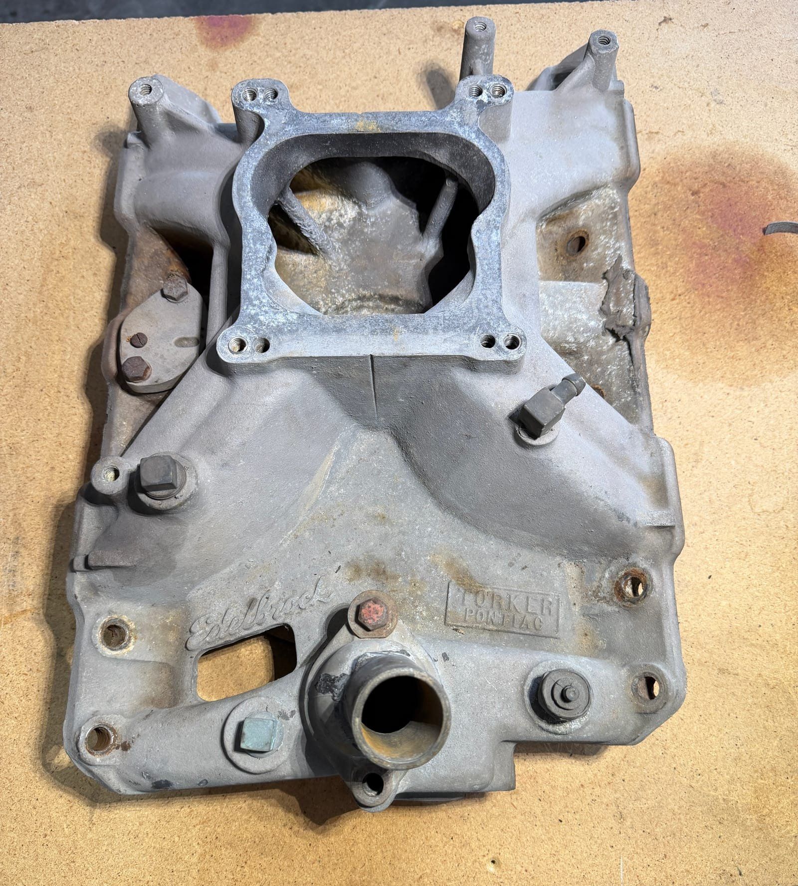 Pontiac intake manifold covered in carbon buildup and oil residue before laser cleaning